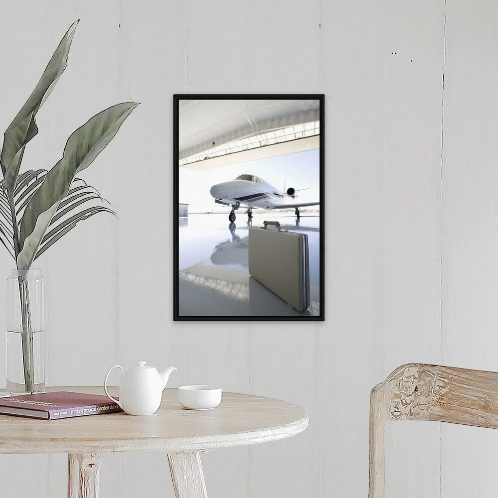 "Briefcase left in hangar near the jet" Black Float Frame Canvas Art