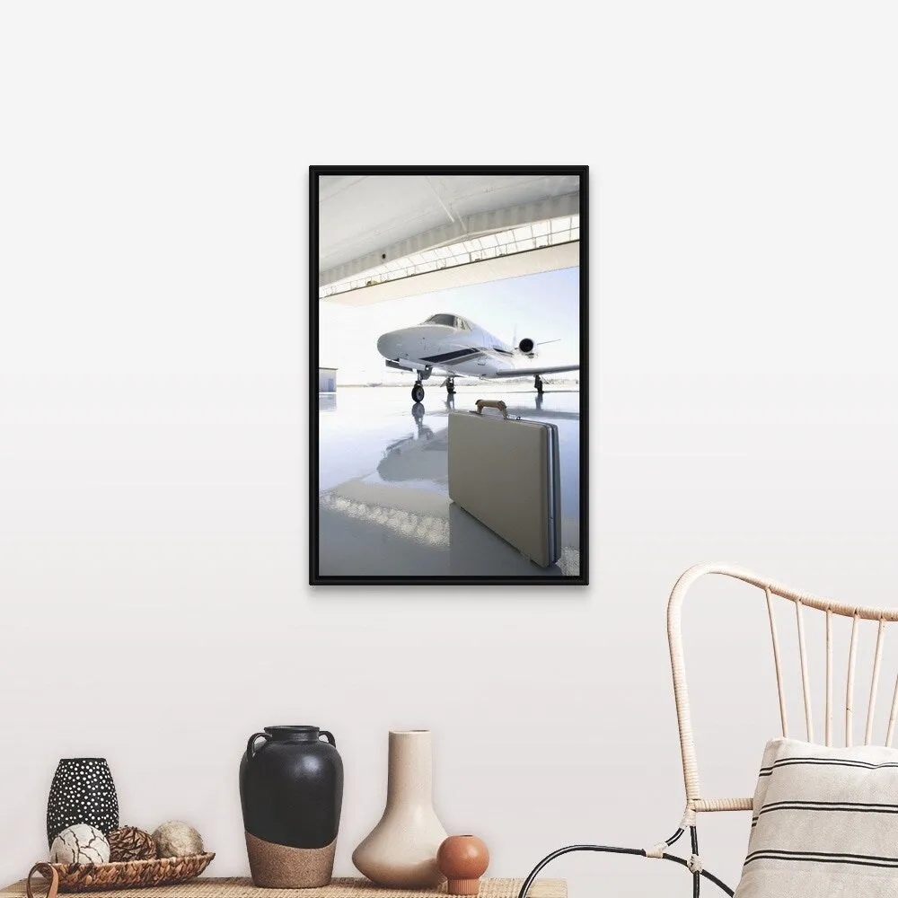 "Briefcase left in hangar near the jet" Black Float Frame Canvas Art